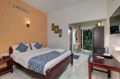 a bedroom with a bed and a desk and a bed sidx sidx sidx at Kurinji Wanderlust Resort Munnar in Munnar