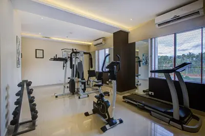 a gym with treadmills and cardio equipment in a room at JK Residency Kelakam in Kelakam