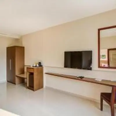 a large empty room with a counter and a tv at JK Residency Kelakam in Kelakam