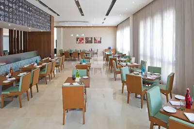 a dining room with tables and chairs in a restaurant at Fairfield by Marriott Coimbatore in Coimbatore