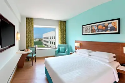 a hotel room with a bed and a large window at Fairfield by Marriott Coimbatore in Coimbatore