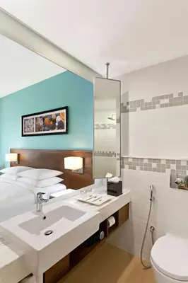 a bathroom with a sink and a toilet and a mirror at Fairfield by Marriott Coimbatore in Coimbatore