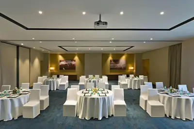 a banquet room with white tables and white chairs at Fairfield by Marriott Coimbatore in Coimbatore