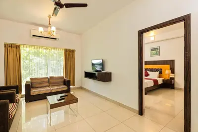 a living room with a couch and a mirror at Casa Rio Resorts Athirappilly in Athirappilly