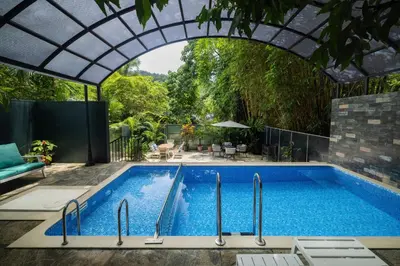 an outdoor swimming pool with an archway over it at Casa Rio Resorts Athirappilly in Athirappilly