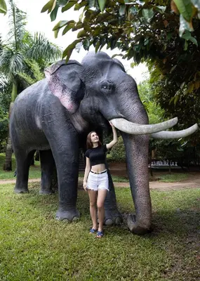 a woman is standing next to an elephant at Casa Rio Resorts Athirappilly in Athirappilly
