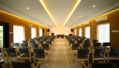 a room with rows of chairs in a hall at Casa Rio Resorts Athirappilly in Athirappilly