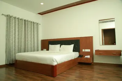 a bedroom with a large bed and a mirror at Four N Square Residency in Palakkad