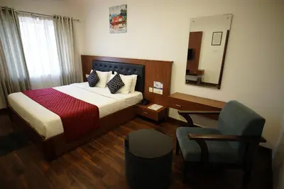 a bedroom with a bed and a desk and a chair at Four N Square Residency in Palakkad