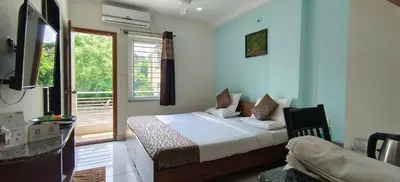 a bedroom with a bed in a room with a window at Sugamya Corner Guesthouse in Mysore