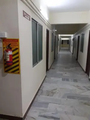 an empty hallway of a building with ailed floor at Hotel Paradise Inn in Tiruppūr