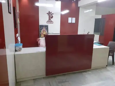 a reception desk in a room with red walls at Hotel Paradise Inn in Tiruppūr