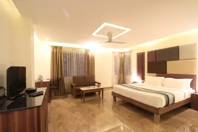 a hotel room with a bed and a television at Sandesh Pride in Mysore