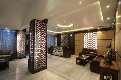 a lobby with a couch and chairs and a table at Sandesh Pride in Mysore
