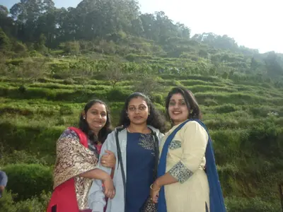 a group of three women standing in front of a hill at Holidays and Celebrations in Kodaikānāl