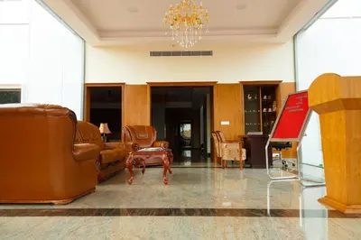 a lobby with leather furniture and a chandelier at Hotel Gopalapuram International in Pollāchi