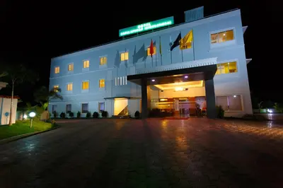 a white building with a sign on it at night at Hotel Gopalapuram International in Pollāchi