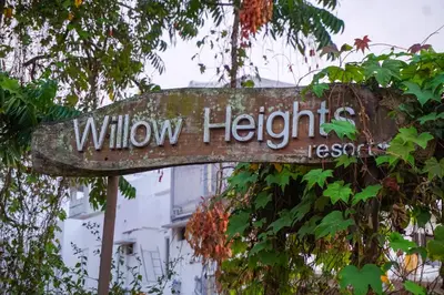a sign that reads wilww heights resort on a tree at Willow Heights in Athirappilly
