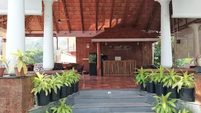 a building with a kiosk with plants in front of it at Willow Heights in Athirappilly