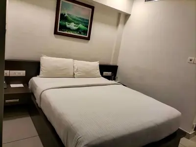 a bedroom with a bed and a picture on the wall at SAAS Residency in Kozhikode