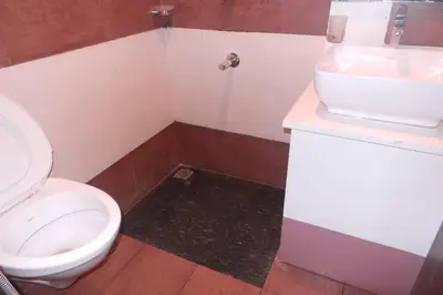 a bathroom with a toilet and a sink at SAAS Residency in Kozhikode