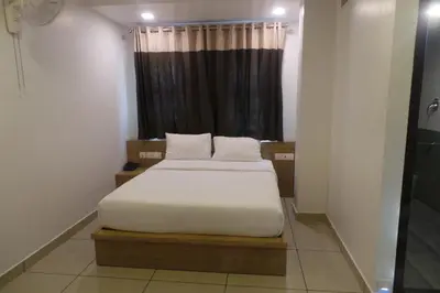 a bedroom with two beds in front of a window at SAAS Residency in Kozhikode