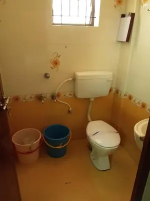 a bathroom with a toilet and a sink at Anandkrishna Residency in Guruvāyūr