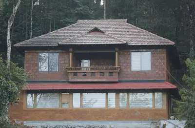 a house with a balcony on top of it at Green Garden Wayanad Villas in Vayittiri