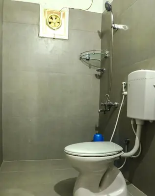 a bathroom with a white toilet in a room at Green Garden Wayanad Villas in Vayittiri