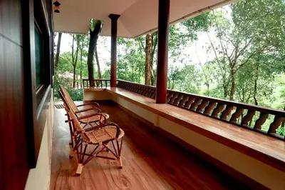 two chairs sitting on the porch of a house at Green Garden Lotus Villa in Kaniyāmbetta