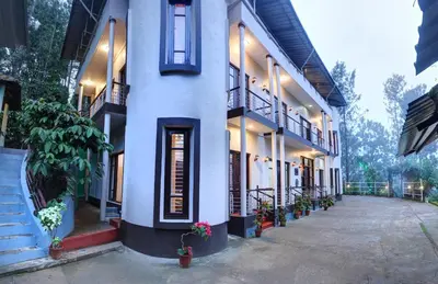 a white building with potted plants on the side of it at Royal Woods Coorg in Madikeri