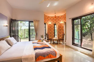 a bedroom with a large bed and large windows at Royal Woods Coorg in Madikeri