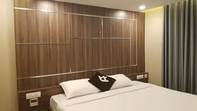 a bedroom with a bed with a black and white pillow at U C plaza in Perintalmanna