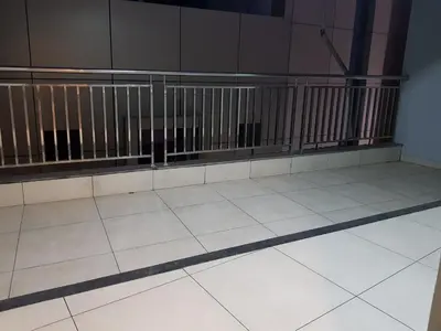 an empty room with a tile floor and a railing at U C plaza in Perintalmanna