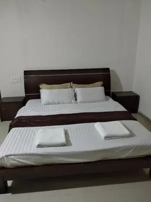 a large bed with two white towels on it at Kwality Estate in Madikeri