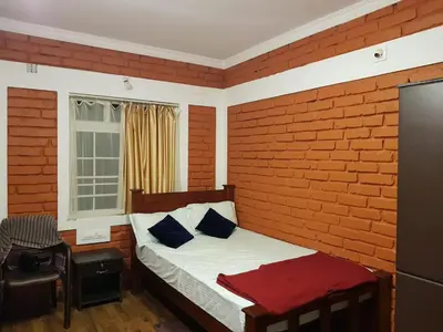 a bedroom with a bed and a brick wall at Marsim Holiday Resort in Vythiri