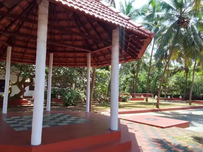 a pavilion at a resort with palm trees in the background at Liberty House - SeaView in Kozhikode