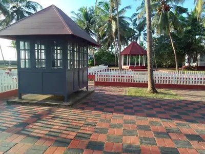 a small building with a white fence and palm trees at Liberty House - SeaView in Kozhikode