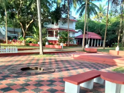 a park with a bench in front of a building at Liberty House - SeaView in Kozhikode