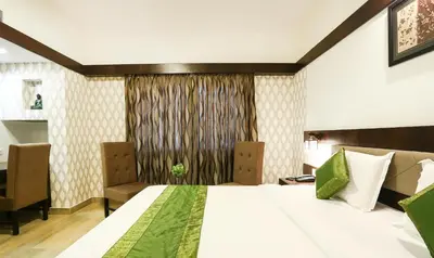 a bedroom with a large white bed and a window at Treebo Premium Akshaya Mahal Inn in Mysore