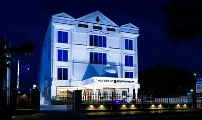a white building with lights in front of it at night at Treebo Premium Akshaya Mahal Inn in Mysore