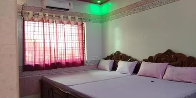 a bedroom with two beds and a window at Sri Priya Lodge in Dharmapuri