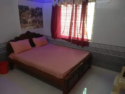 a small bed in a room with a window at Sri Priya Lodge in Dharmapuri