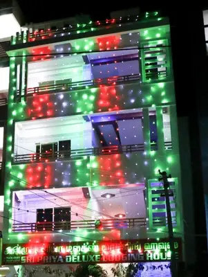 a tall building with green and red lights on it at Sri Priya Lodge in Dharmapuri