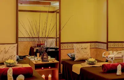 a room with two beds and a table with candles at Fortune Resort Sullivan Court, Ooty - Member ITC Hotels' Group in Ooty
