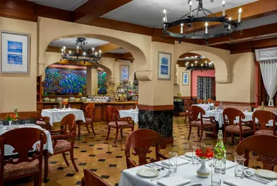 a restaurant with tables and chairs and a bar at Fortune Resort Sullivan Court, Ooty - Member ITC Hotels' Group in Ooty