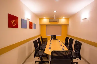a conference room with a long table and chairs at Ginger Mysore in Mysore