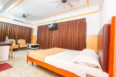 a bedroom with a bed and a desk in a room at Hotel Srilakshmi in Coimbatore