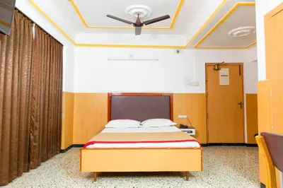 a bedroom with a bed and a ceiling fan at Hotel Srilakshmi in Coimbatore