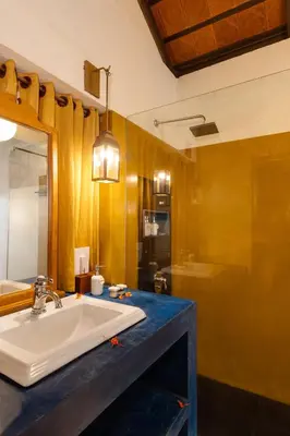 a bathroom with a white sink and a mirror at Cranganor History Café & Riverside Château in Parūr